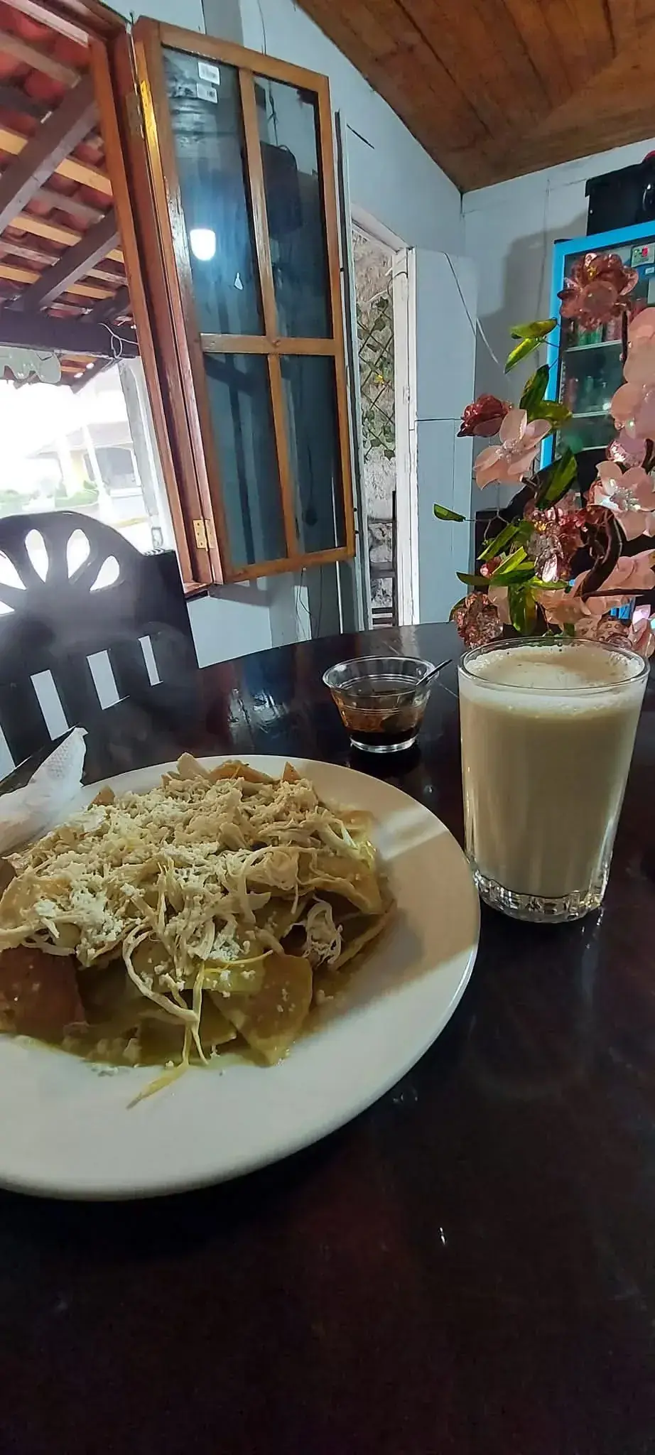 Plato de chilaquiles tradicionales con pollo, queso, crema y lechuga