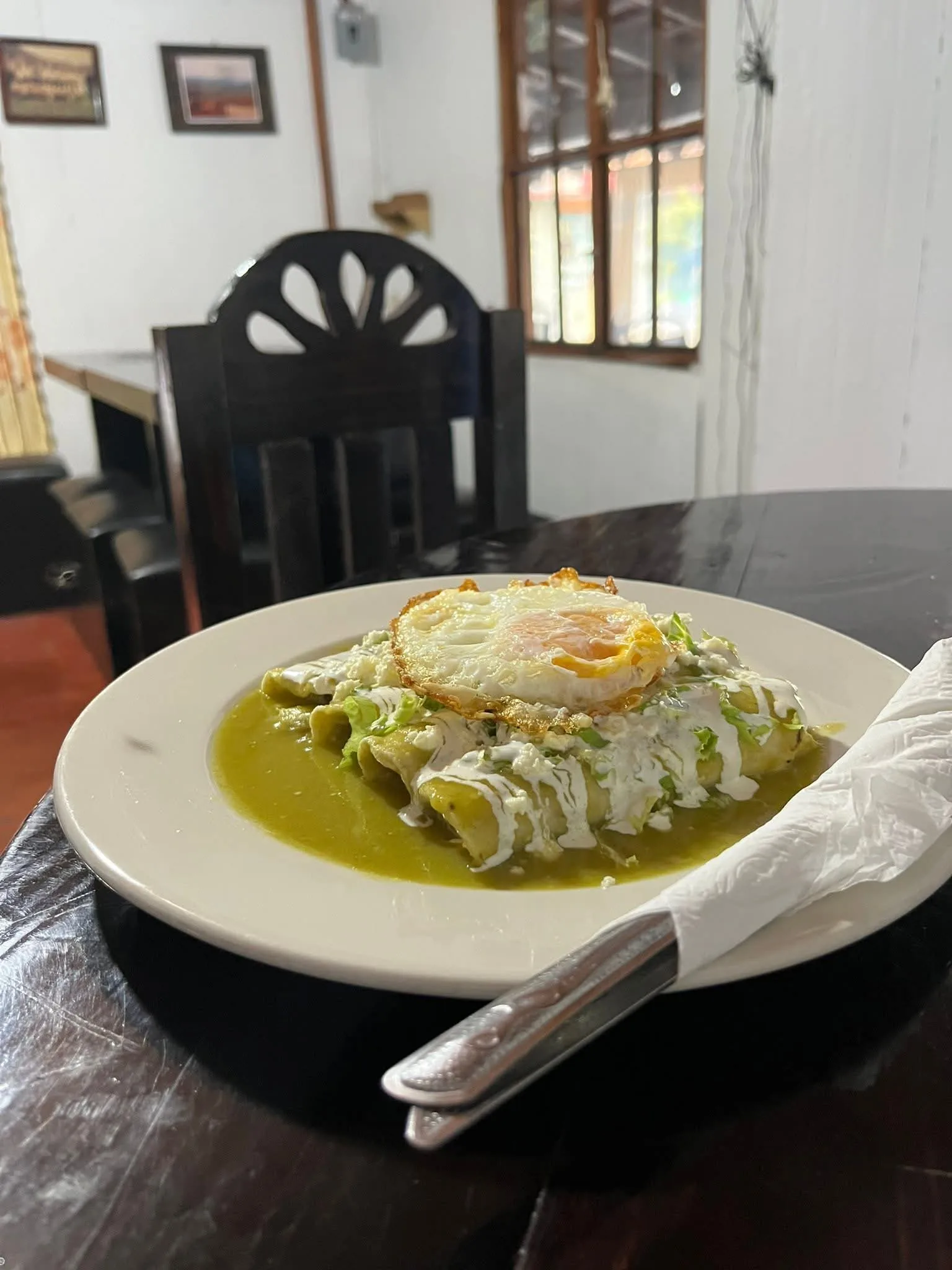 Enchiladas tradicionales en salsa verde, con crema, lechuga y un huevo estrellado encima